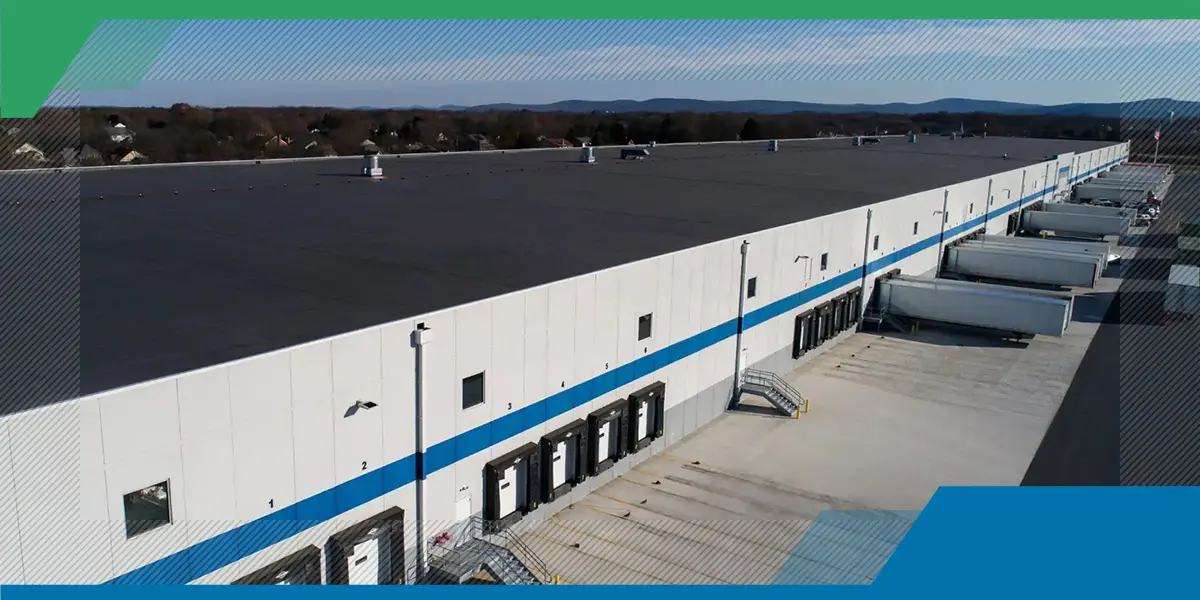 An aerial view of a large warehouse with trucks parked in front of it